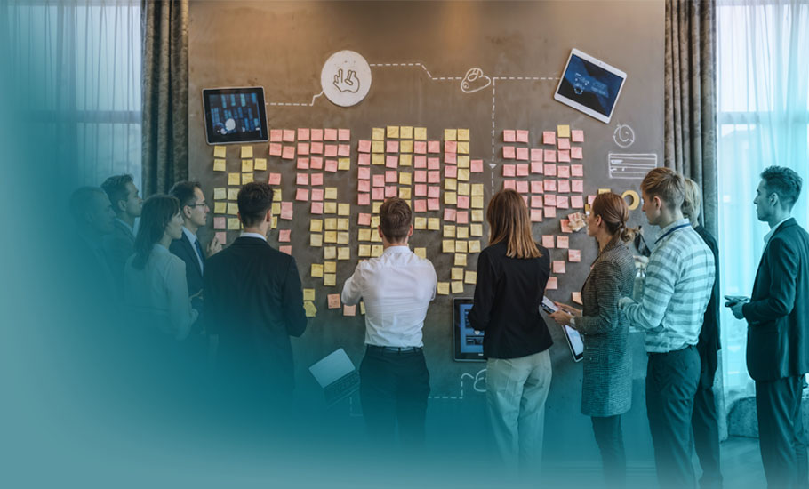 Stakeholdermanagement im Projekt: Geschäftsleute analysieren gemeinsam eine Wand voller Post-its und Notizen während eines strategischen Planungsmeetings.